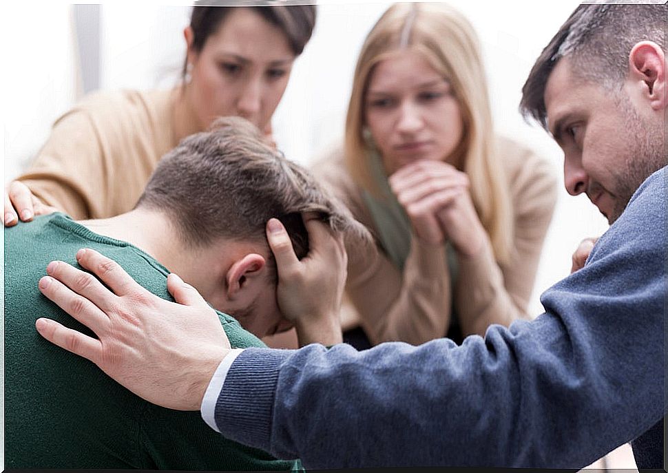 man receiving support from his friends