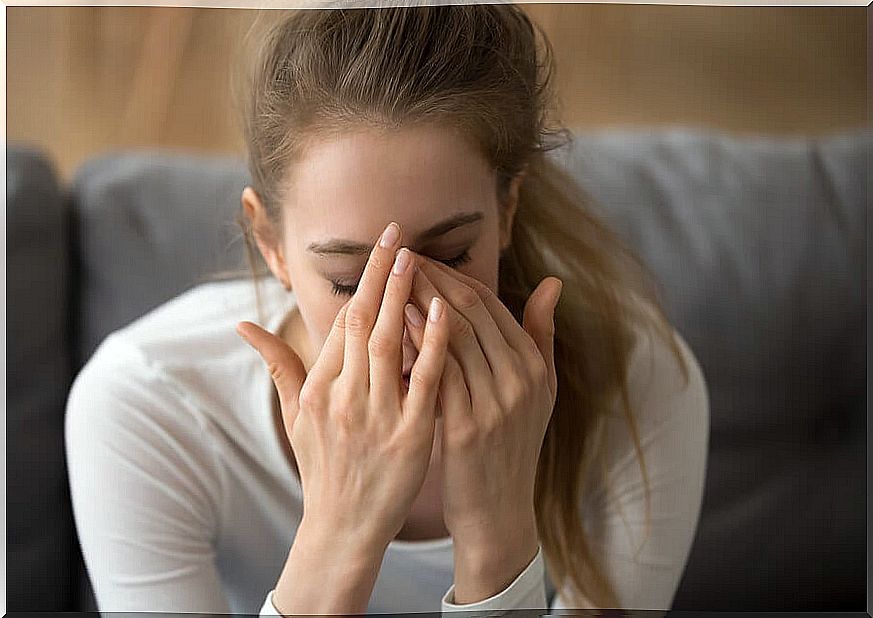 Woman with eyes closed in an anxiety attack.