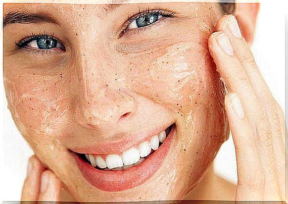 Woman applying scrub to her skin.