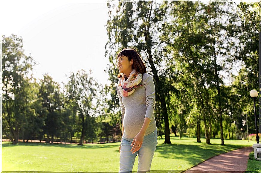 Pregnant woman walking in a park