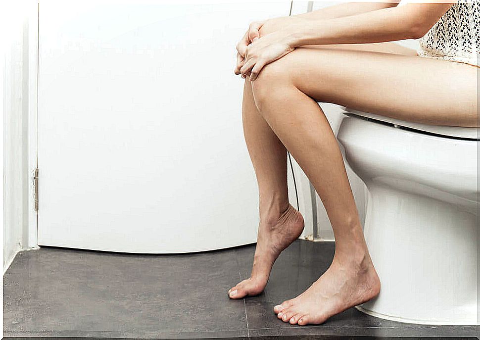 Woman urinating in toilet.